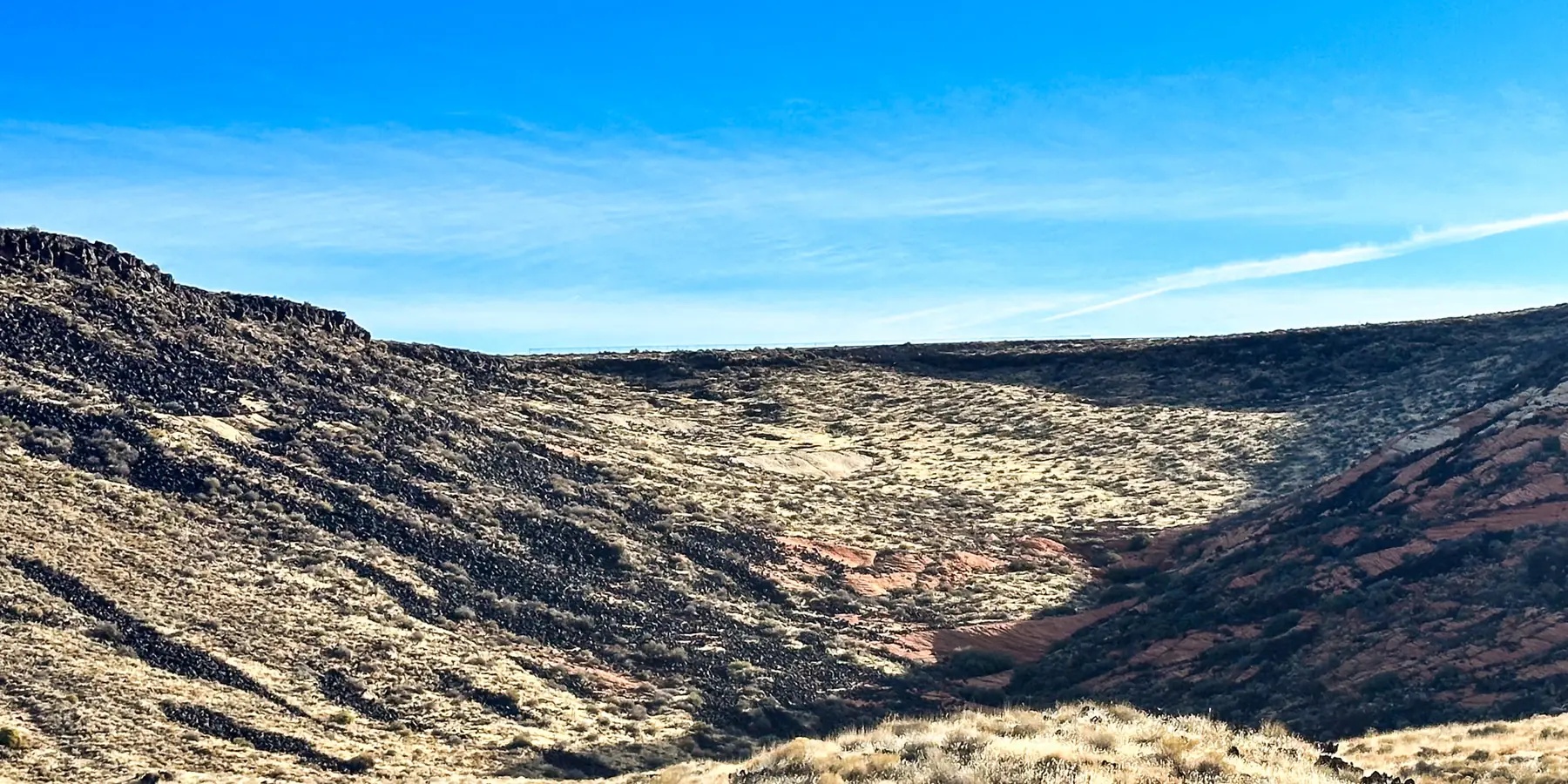 A view down into a lava-floored side canyon with sandstone cliffs on the far side, Snow Canyon State Park.