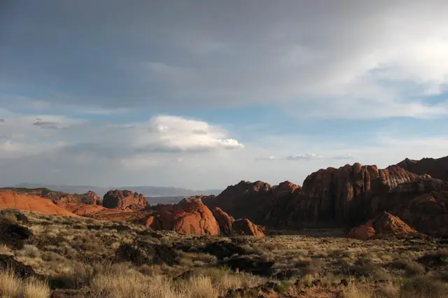 Soft evening light on red sandstone below a cloudy sky in Snow Canyon State Park.