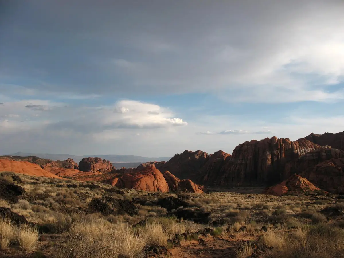 Soft evening light on red sandstone below a cloudy sky in Snow Canyon State Park.