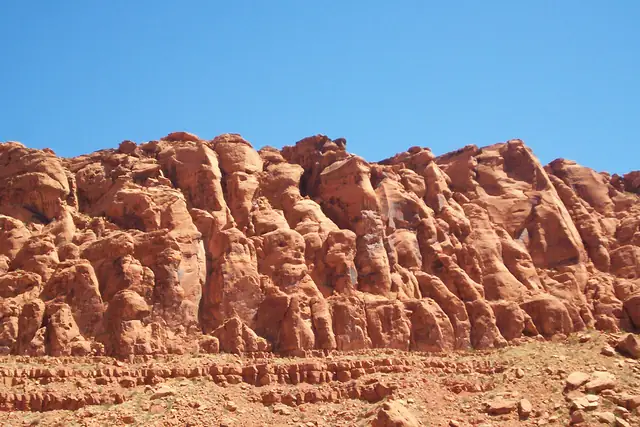 A wall of rounded red Navajo Sandstone formations under a blue sky in Snow Canyon State Park.