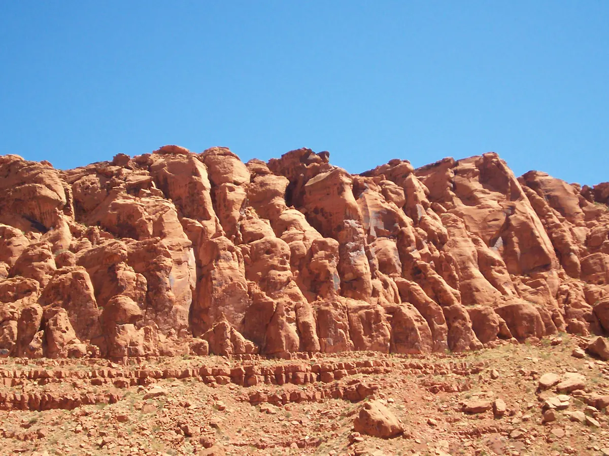 A wall of rounded red Navajo Sandstone formations under a blue sky in Snow Canyon State Park.