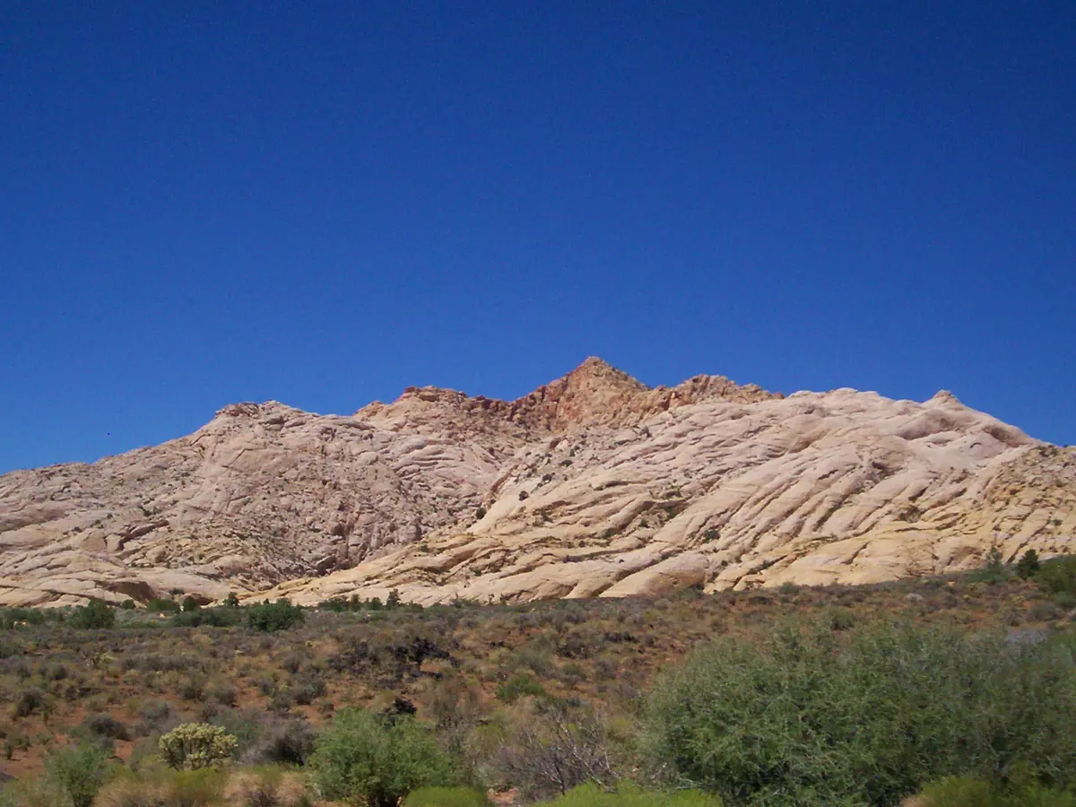 A long ridge of white Navajo Sandstone above desert scrub in Snow Canyon State Park.